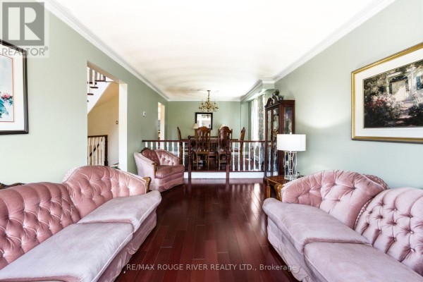 Living and dining room with light green walls, plush pink sofas, and dark wood floors. - 51 Sugarbush Square, Toronto