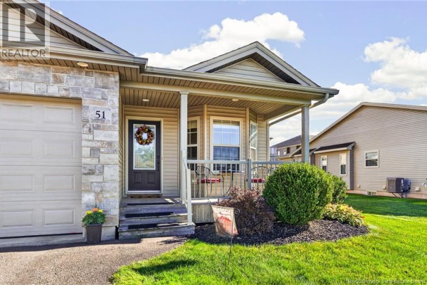 Close up of the covered front porch with a dark brown door, wreath, and seating area. - 51 Thornhill Crescent, Moncton