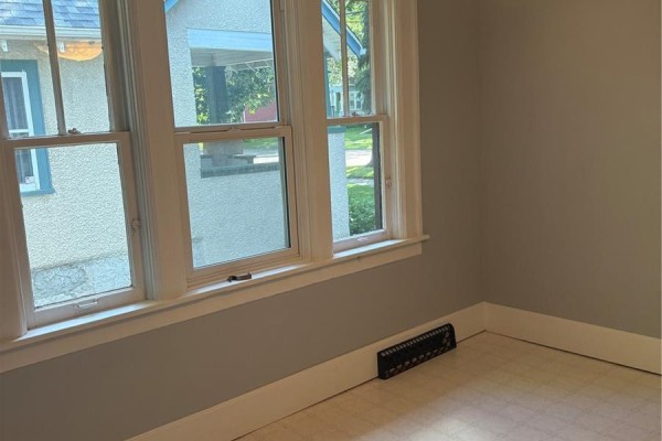 Kitchen with white stove, wood cabinets, and a sink area with a window. - 51 Tupper Avenue, Yorkton