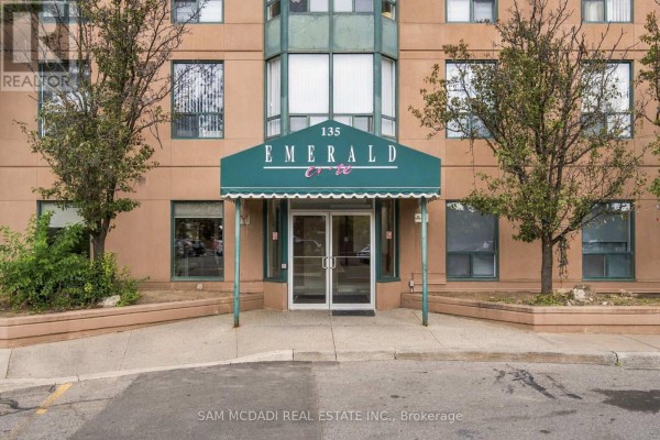 Exterior entrance of the Emerald building with a green awning over double glass doors. - 510 - 135 Hillcrest Avenue, Mississauga