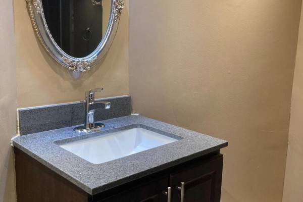 A bathroom vanity with a white sink, chrome faucet, and granite countertop. - 510 - 38 Elm Street, Toronto