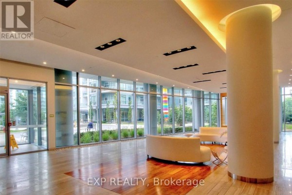 Bright condo lobby with floor-to-ceiling windows, modern furniture, and wood flooring. - 510 - 70 Forest Manor Road, Toronto