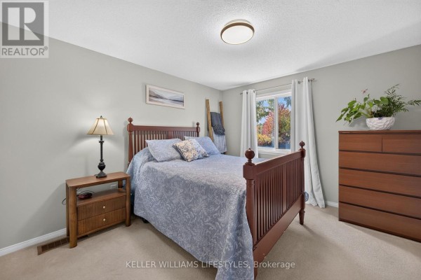 Open-concept kitchen with wooden cabinets, stainless steel appliances, and adjacent living area. - 510 Blackwater Place, London North