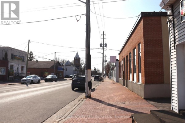 Street view of the building with parked cars and surrounding commercial properties. - 510 Main Street, North Dundas