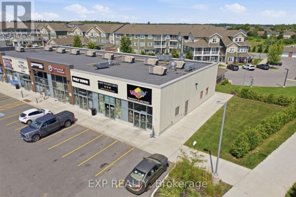 Aerial view of a commercial building with several businesses and surrounding residential units. - 5100 Kanata Avenue, Ottawa