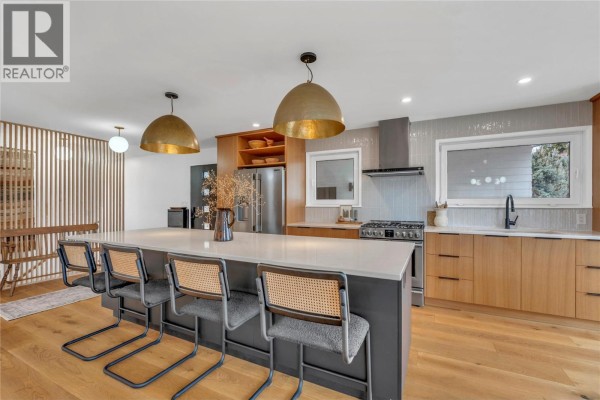 Walk-in closet featuring wooden shelving and organized clothing storage. - 5100 Wilson Road, Summerland