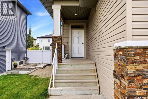 A bathroom with a dark brown vanity, white countertop, toilet, bathtub with shower curtain, and tiled floor. - 5101 Tutor Way, Regina