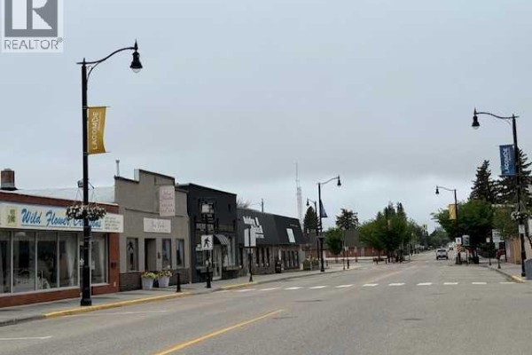 Dark grey commercial building facade with "Jones Denture Clinic" and "TimeWorn Charm" signs. - 5105 50 Avenue, Lacombe