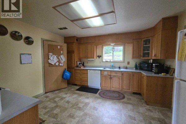 Kitchen with light wood cabinets, beige countertops, white appliances, and vinyl flooring. - 5106 Center Avenue, Robb