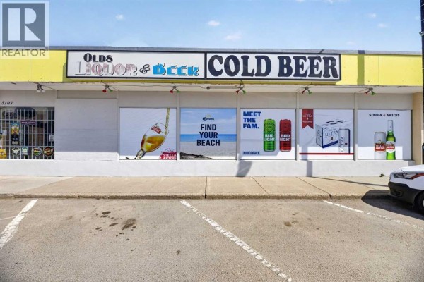 Front exterior signage on the commercial building advertising "Olds Liquor & Beer" and "Cold Beer" with large graphics. - 5107 50 Avenue, Olds