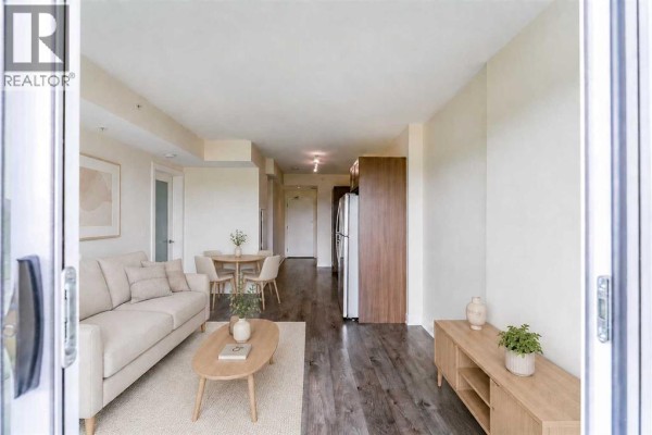 Apartment kitchen with dark wood cabinets, stainless steel appliances, and a granite countertop. - 511, 30 Brentwood Common Nw, Calgary