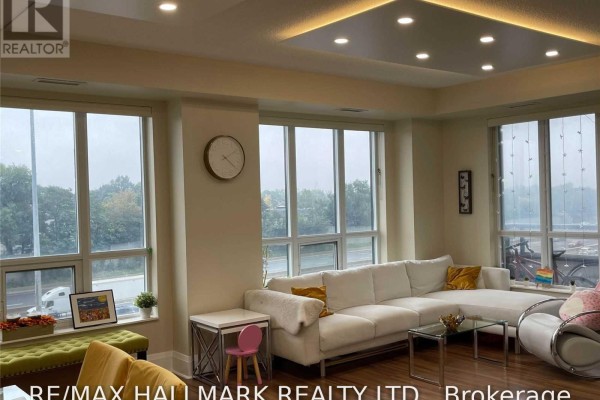 A living room with a large white sectional sofa and floor-to-ceiling windows. - 512 - 100 Harrison Garden Boulevard, Toronto