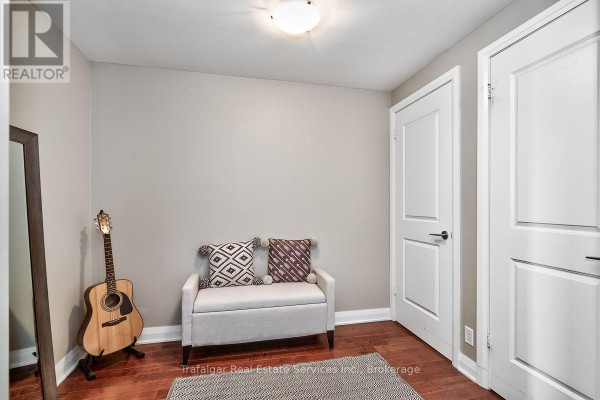 Interior room with neutral walls, hardwood floors, a bench, and two white doors. - 512 - 1055 Southdown Road, Mississauga