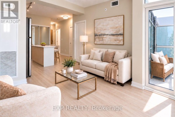 Living room with a beige sofa, glass coffee table, and light wood flooring. - 512 - 621 Sheppard Avenue E, Toronto