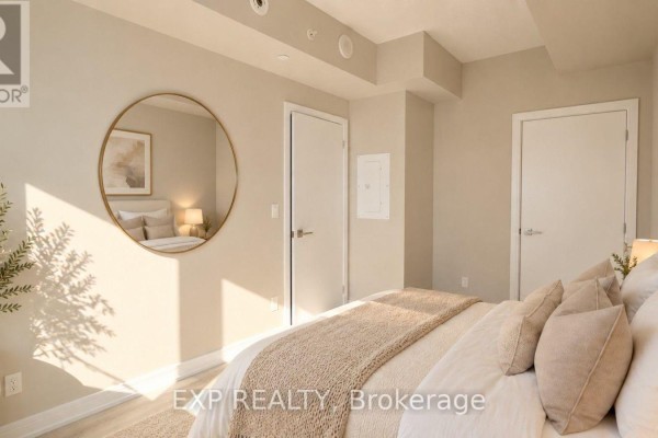 Bedroom with a king-sized bed, light wood flooring, and two doors visible. - 512 - 621 Sheppard Avenue E, Toronto