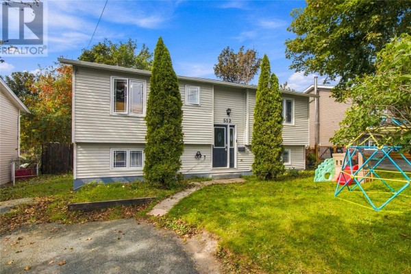 Front exterior of a light grey, two-story house with a dark driveway and green lawn. - 512 Main Road, St John S