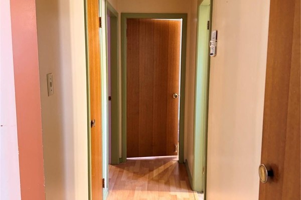 Interior hallway with light wood laminate flooring and several interior doors. - 512 Mcnab Street, Burstall