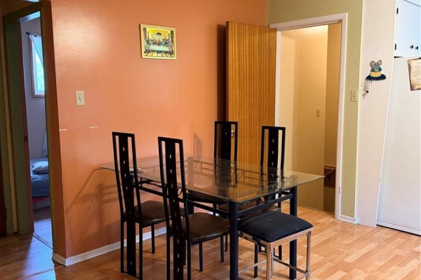 Dining area with a glass-top table and chairs, adjacent to a doorway into another room. - 512 Mcnab Street, Burstall