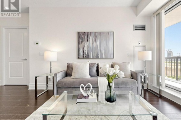 A spacious lounge area with multiple seating arrangements, a fireplace, and a bar area with high stools. - 513 - 131 Upper Duke Crescent, Markham