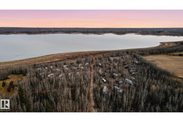 Aerial view of RVs and campers nestled within a wooded area near a lake. - 51380a Rge Road 205, Rural Strathcona County