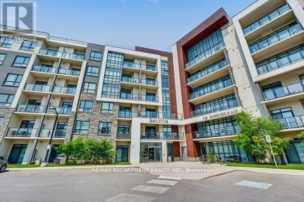 Facade of a multi-story apartment building with balconies and street-level commercial spaces. - 514 - 125 Shoreview Place, Hamilton