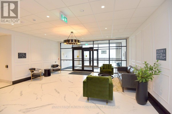 Apartment building lobby with marble floors, green velvet chairs, and a black sofa. - 514 - 1936 Rymal Road E, Hamilton