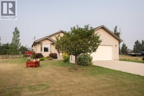 Side angle of the house with a small tree and landscaped yard. - 514 6a Street N, Champion