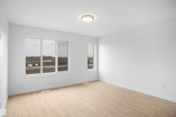 Hallway with two doors, carpet flooring, and mirrored closet - 5143 River's Edge Wy Nw, Edmonton