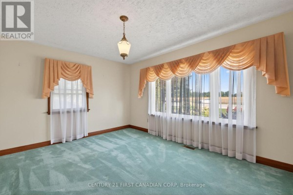 Teal carpet living room with bay window and pendant light - 5147 Egremont Drive Middlesex Centre