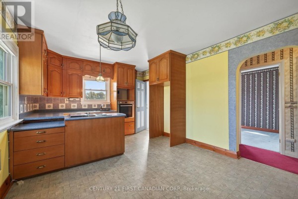Room with wood paneling, grey carpet, and a closed doorway with brown curtains. - 5147 Egremont Drive, Middlesex Centre