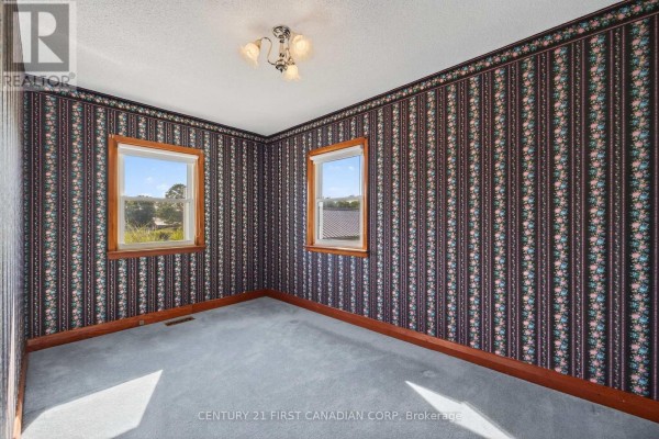 Bedroom with floral wallpaper, carpet, and two windows - 5147 Egremont Drive Middlesex Centre