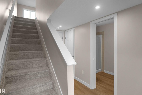 Entryway featuring a modern front door, staircase, and access to additional rooms - 5147 River's Edge Wy Nw, Edmonton