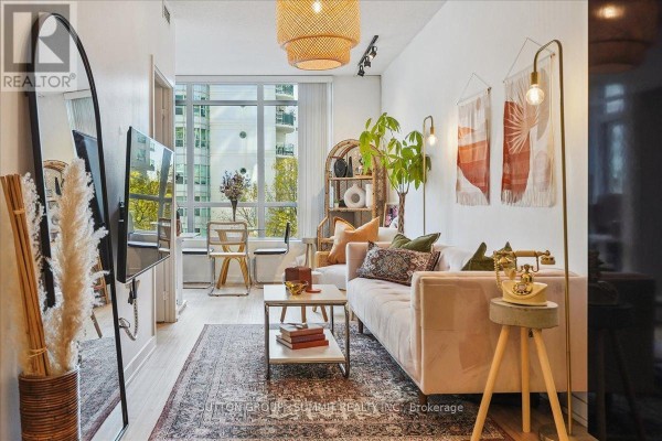 Pink sofa, large window, and vintage telephone in living room - 515 - 38 Dan Leckie Way Toronto