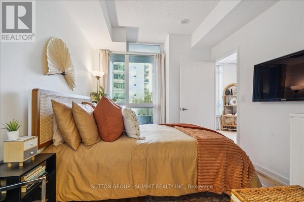 Bedroom with rattan headboard, accent pillows, and city view - 515 - 38 Dan Leckie Way Toronto