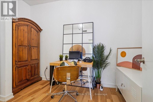Home office with wooden armoire, desk, chair, mirror, plant, and artwork - 515 - 38 Dan Leckie Way Toronto