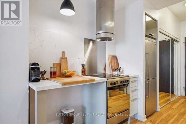 Modern kitchen with stainless steel appliances, quartz backsplash, and mirrored doors - 515 - 38 Dan Leckie Way Toronto