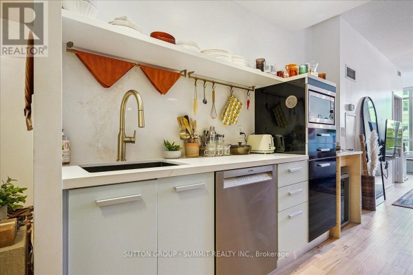 Kitchen with gold faucet, dishwasher, microwave, and open shelving - 515 - 38 Dan Leckie Way Toronto