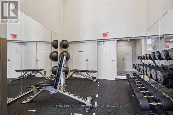 Weight benches, dumbbells, and medicine balls in a gym with mirrors - 515 - 38 Dan Leckie Way Toronto