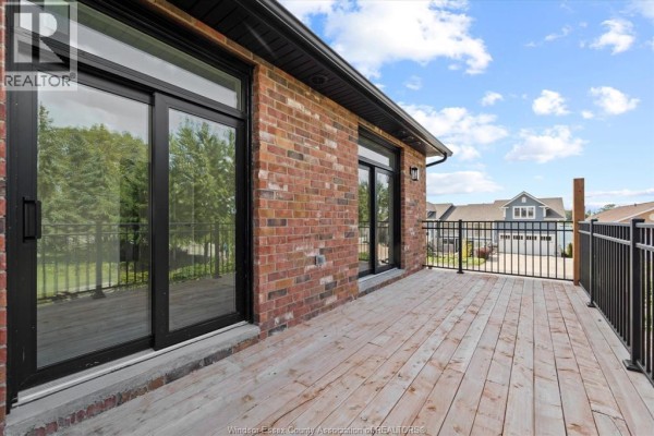 Wooden deck with black metal railing and view of surrounding houses. - 515 Dalhousie Street Unit# 2b, Amherstburg