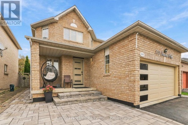 Close-up of the entrance to a brick house with a hanging chair on the porch. - 515 Ormond Drive, Oshawa