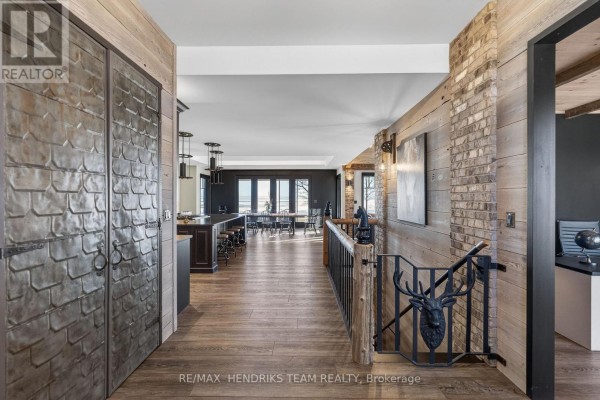 Interior hallway with decorative metal doors, hardwood flooring, and open layout. - 515 Sandy Bay Road, Haldimand