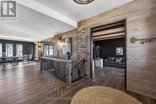 Living area with wooden walls, large windows, and a view of the outdoors. - 515 Sandy Bay Road, Haldimand