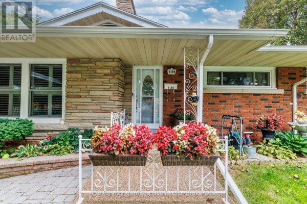 Close-up of the front door area featuring decorative planters and ornamental porch supports. - 5159 Shirley Avenue, Niagara Falls
