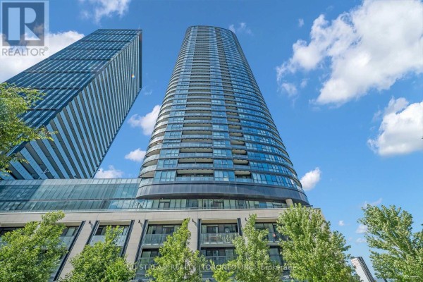 A tall, contemporary condo building with glass balconies against a cloudy sky. - 516 - 585 Bloor Street E, Toronto