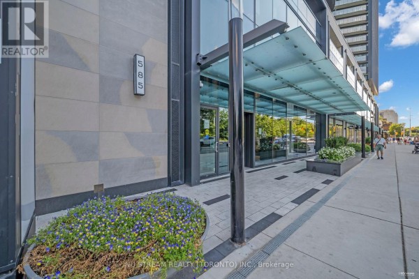 The building entrance at 585 Bloor Street East with glass doors and stone facade. - 516 - 585 Bloor Street E, Toronto