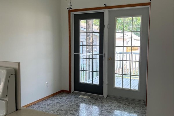 Kitchen with french doors leading to a wooden deck outside. - 516-518 Centre Street, Shaunavon