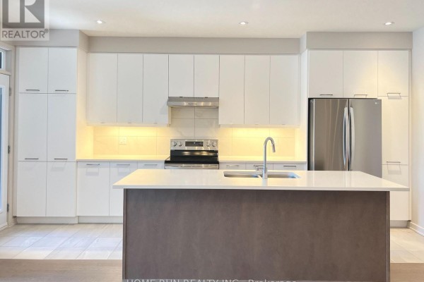 Modern kitchen with white cabinetry, stainless steel appliances, and a grey island. - 516 Borbridge Avenue, Ottawa