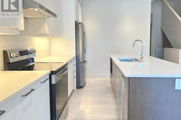 Kitchen with white cabinets, stainless steel appliances, quartz countertops, and island. - 516 Borbridge Avenue, Ottawa