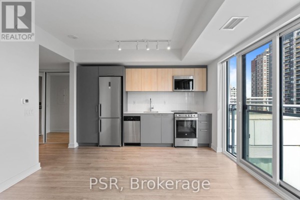 The apartment features a combined living and kitchen area with a large sliding glass door leading to a balcony. - 517 - 299 Campbell Avenue, Toronto