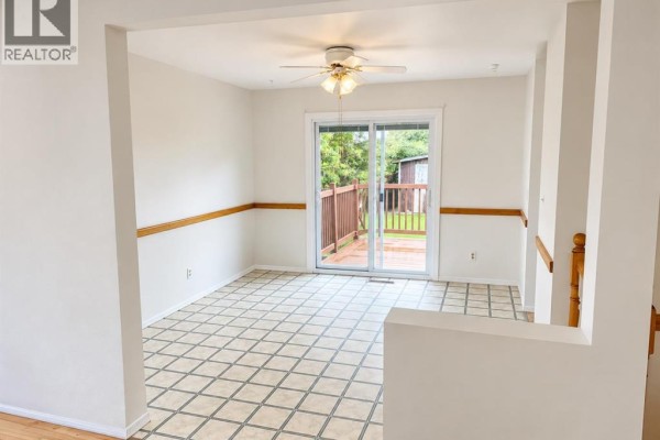 Bathroom with a white toilet, oak vanity, white sink, and a glass-enclosed shower. - 517 55 Avenue W, Claresholm